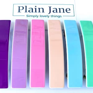 Op de afbeelding: Zes kleurrijke haarclips in een regenboogkleurige gradiënt. De clips zijn gemaakt van plastic en hebben een gladde, glanzende afwerking. De kleuren zijn paars, lavendel, roze, perzik, lichtblauw en mintgroen.