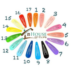 May include: A set of 17 colorful hair clips arranged in a circle. The clips are all the same size and shape, and they are made of metal. The clips are in a variety of colors, including red, orange, yellow, green, blue, purple, and pink. The text "HOUSE OF CLIPS" is in the center of the circle.