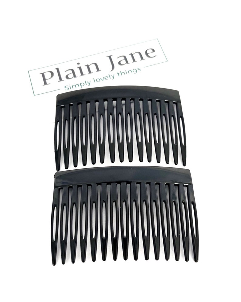 May include: Two black hair combs with multiple teeth, arranged one above the other. The combs have a curved top and are set against a white background. The text "Plain Jane Simply lovely things" is in the upper right corner.