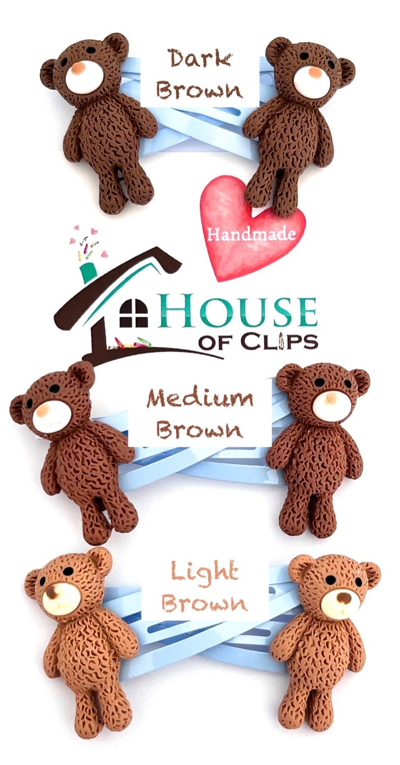 May include: Three teddy bear hair clips in different shades of brown: dark brown, medium brown, and light brown. The clips are handmade and feature a house logo with the text "House of Clips".