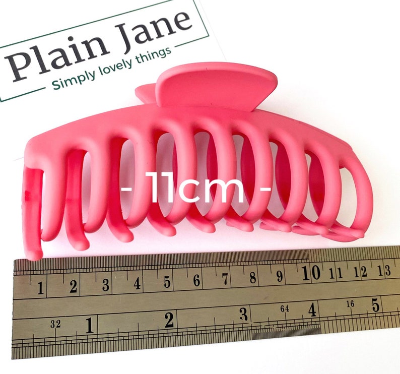 Puede incluir: Una pinza para el pelo de pl&aacute;stico rosa brillante que mide 11 cm de largo. La pinza tiene varios dientes para sujetar el pelo en su lugar.