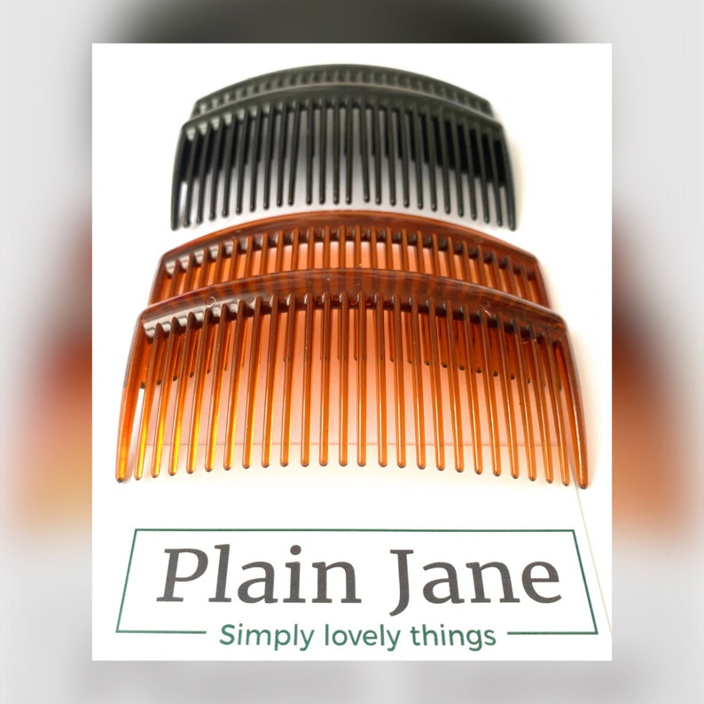 May include: Three plastic hair combs, two brown and one black, are stacked on top of each other. The combs are curved and have a wide tooth design.