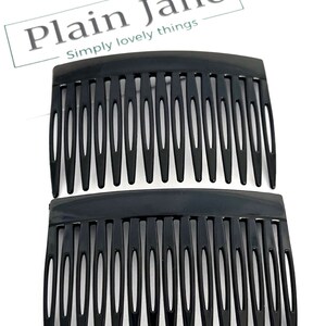May include: Two black hair combs are shown against a white backdrop. The combs are made of a glossy black material and have a series of evenly spaced teeth. The text "Plain Jane" and "Simply lovely things" is in the upper left corner.