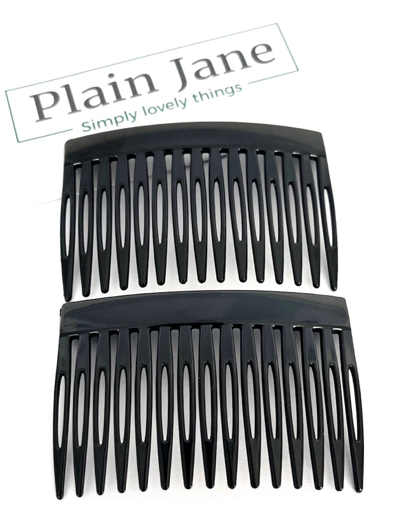 May include: Two black hair combs are shown against a white backdrop. The combs are made of a glossy black material and have a series of evenly spaced teeth. The text "Plain Jane" and "Simply lovely things" is in the upper left corner.