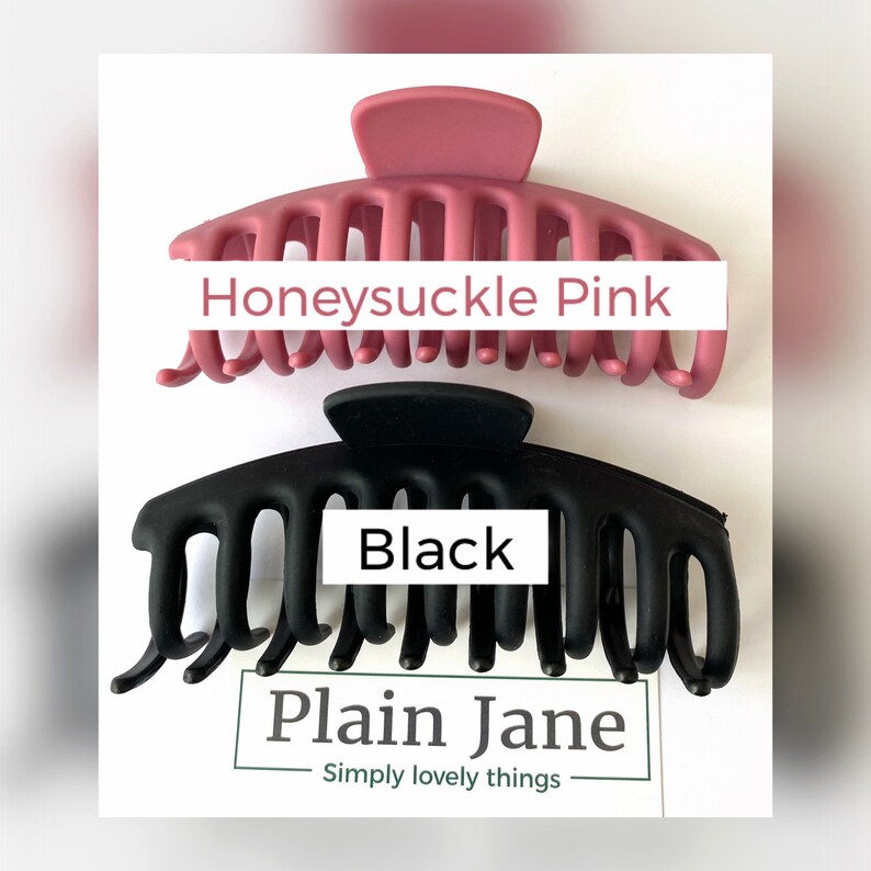 Puede incluir: Dos grandes pinzas para el pelo de pl&aacute;stico, una en negro y otra en color rosa polvoriento. Las pinzas tienen forma de garra con varios dientes. El texto "Honeysuckle Pink" est&aacute; escrito en la pinza rosa y "Black" est&aacute; escrito en la pinza negra. El texto "Plain Jane" est&aacute; escrito debajo de las pinzas.