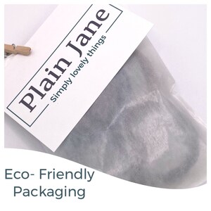May include: A white envelope with the text "Plain Jane - Simply lovely things" printed on it. The envelope is made of eco-friendly paper and is being used to package a product.