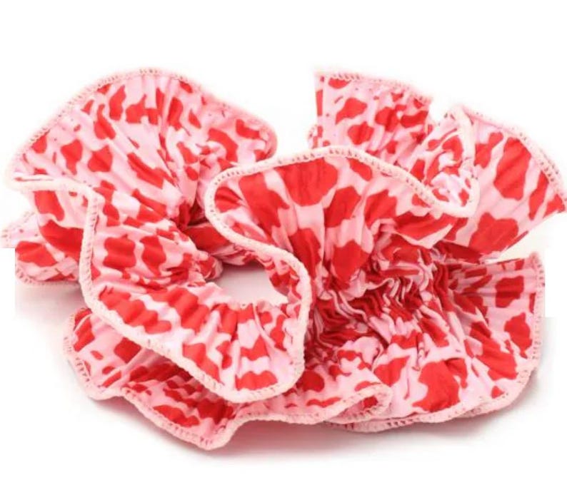May include: A pink and red patterned hair scrunchie with a ruffled design.