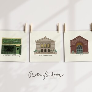 May include: Three square art prints of Chicago landmarks hang from a string with wooden clothespins. The prints depict The Green Mill Cocktail Lounge, The Art Institute of Chicago, and Lincoln Park Zoo, with text below each.