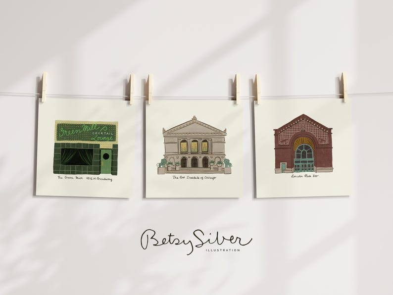 May include: Three square art prints of Chicago landmarks hang from a string with wooden clothespins. The prints depict The Green Mill Cocktail Lounge, The Art Institute of Chicago, and Lincoln Park Zoo, with text below each.