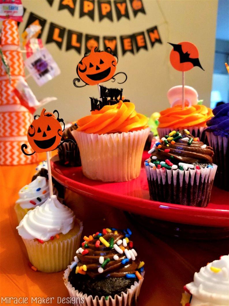 Halloween cupcake toppers featuring cute smiling pumpkins and bold black bats. The pumpkins are orange with a black background. While the bats are black flying over an orange moon. A perfect addition to a Halloween dessert table.