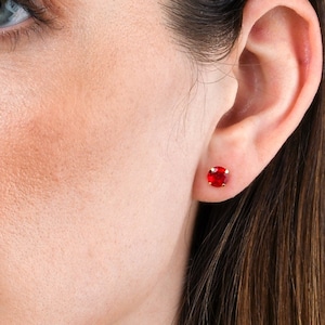 Könnte beinhalten: Nahaufnahme eines Frauen Gesichts mit einem roten Edelstein Ohrring am rechten Ohr.