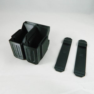 May include: A black plastic double magazine holder with two black plastic belt clips.