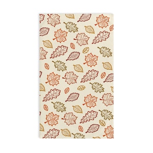 Pode incluir: Toalha retangular creme com um padrão repetido de folhas de outono em tons de laranja, castanho e verde. As folhas têm o texto "FUCK TRUMP" impresso.