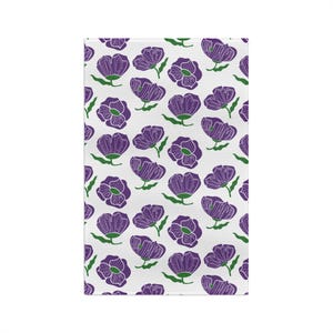 May include: White rectangular kitchen towel with a repeating pattern of purple flowers with green stems and leaves. The flowers are stylized with a simple outline, creating a clean and modern aesthetic. The towel is likely made of a soft, absorbent material.