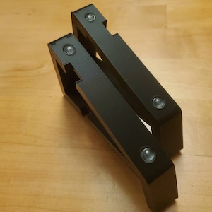 Puede incluir: Dos soportes de estante de pl&aacute;stico negro con cuatro agujeros de tornillo visibles.