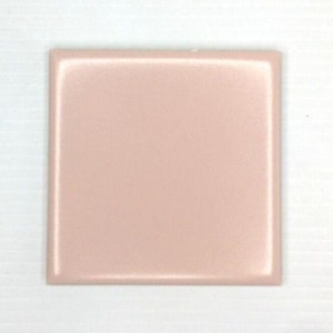 Può includere: Una piastrella quadrata in ceramica con una finitura liscia e lucida in un colore rosa cipria chiaro uniforme. La piastrella presenta bordi dritti e netti e una superficie riflettente che cattura la luce, creando un aspetto omogeneo su tutta la superficie.