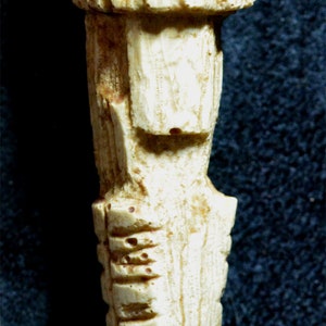 以下が含まれることがあります： 彫刻された象牙の置物で、頭部は細部まで作り込まれ、体は長く細いです。この置物は伝統的な民芸品です。