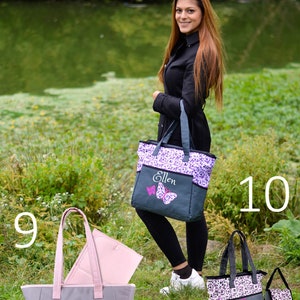 May include: Two gray and purple tote bags with the name "Ellen" embroidered on them. The bags have different patterns, one with butterflies and the other with polka dots and a bear. Both bags have a zippered pocket and a changing pad.