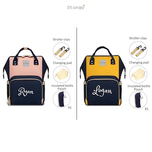 May include: Two diaper bags with personalized names, Ryan and Logan. The bags are navy blue with gold accents and have a pink and yellow exterior. Each bag comes with a changing pad, stroller clips, and an insulated bottle pouch.