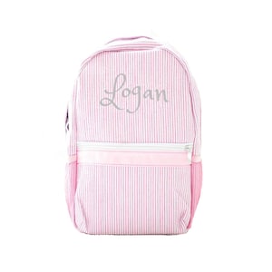 May include: Pink and white striped backpack with a silver embroidered name "Logan".