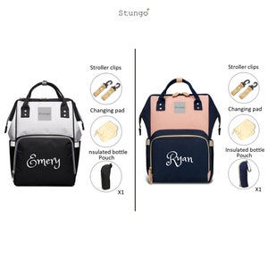 May include: Two diaper bags with different color combinations. The bag on the left is gray and black with the name "Emery" embroidered on the front. The bag on the right is pink and navy blue with the name "Ryan" embroidered on the front. Both bags include a changing pad, stroller clips, and an insulated bottle pouch.