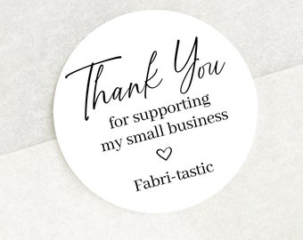 May include: A circular white sticker with black text that reads Thank You for supporting my small business, followed by a small heart icon and the word Fabri-tastic. The sticker is placed on white tissue paper inside a brown cardboard box.