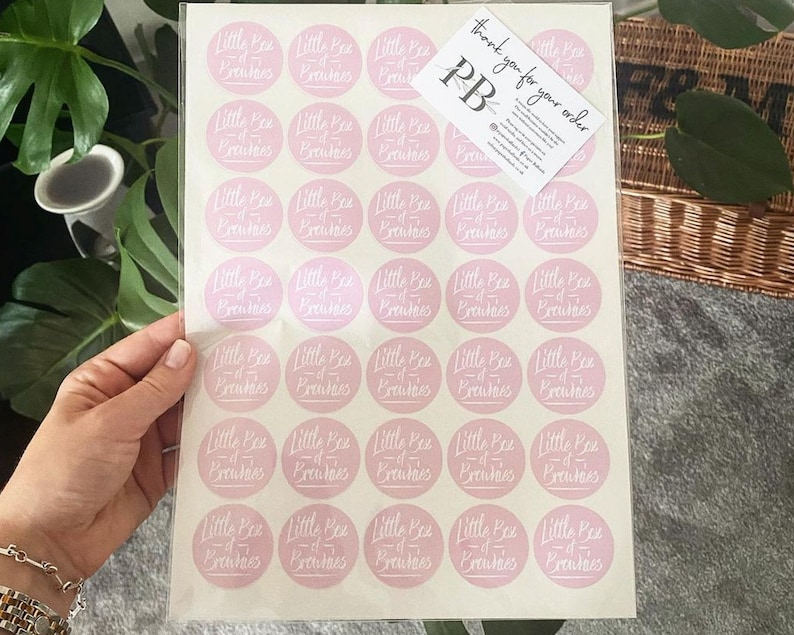 May include: A sheet of 36 pink round stickers with the text "Little Bee of Brews" in white script. The sheet is on a white background. The text "thank you for your order" is written on a small white card with the letters "PB" in black.