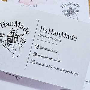 K&ouml;nnte beinhalten: Eine wei&szlig;e Visitenkarte f&uuml;r einen H&auml;keldesigner mit einem schwarzen Strichzeichnungs-Logo einer Hand, die ein Garnkn&auml;uel und eine H&auml;kelnadel h&auml;lt. Der Text lautet HanMade, ItsHanMade, Crochet Designer, @itshanmade_, itshanmade.co.uk und itshanmadecrochet@gmail.com.