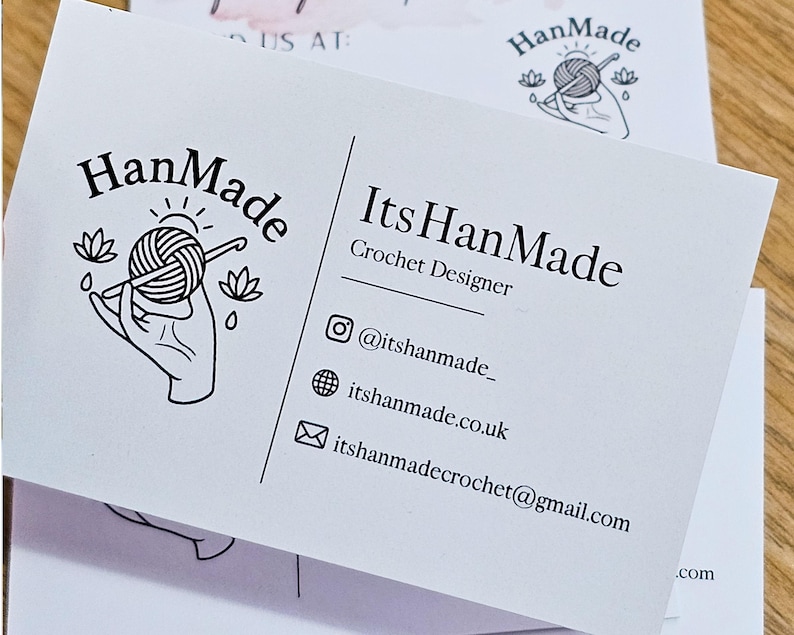 K&ouml;nnte beinhalten: Eine wei&szlig;e Visitenkarte f&uuml;r einen H&auml;keldesigner mit einem schwarzen Strichzeichnungs-Logo einer Hand, die ein Garnkn&auml;uel und eine H&auml;kelnadel h&auml;lt. Der Text lautet HanMade, ItsHanMade, Crochet Designer, @itshanmade_, itshanmade.co.uk und itshanmadecrochet@gmail.com.