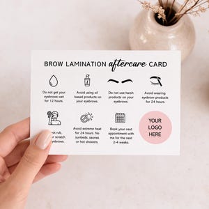 May include: A white card with the text "BROW LAMINATION aftercare CARD" and aftercare instructions. The card includes icons and text advising on post-treatment care, such as avoiding water, oil-based products, and heat. A pink circle is labeled "YOUR LOGO HERE".