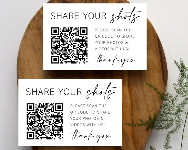 May include: Two white cards with black text and a black and white QR code. The text on the cards reads "SHARE YOUR shots" and "PLEASE SCAN THE QR CODE TO SHARE YOUR PHOTOS & VIDEOS WITH US! thank you".