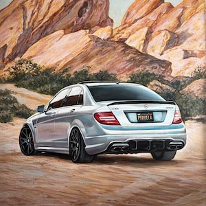 Può includere: Una berlina Mercedes-Benz C63 AMG argentata parcheggiata in un paesaggio desertico. L'auto ha uno spoiler nero, cerchi neri e una targa della California che recita "PEDULLA".