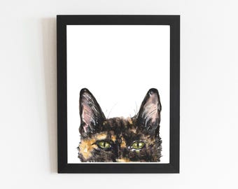Könnte beinhalten: Gerahmter Aquarelldruck eines Katzenkopfes mit grünen Augen und schwarzem, braunem und hellbraunem Fell. Die Ohren der Katze sind über den Augen zu sehen. Das Kunstwerk ist in einem schwarzen Rahmen.
