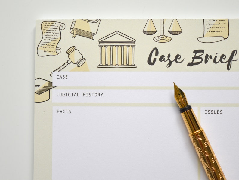 May include: A white notepad with a yellow background and black illustrations of scales, a building, and scrolls. The notepad has the words "Case Brief" written in black cursive. The notepad is divided into sections labeled "Case", "Judicial History", "Facts", and "Issues". A gold pen is lying on the notepad.