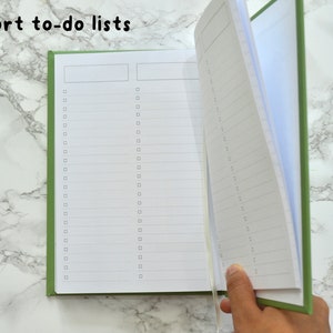 May include: A green notebook with the words "Short to-do lists" printed on the cover. The notebook is open to a blank page with lines and checkboxes.