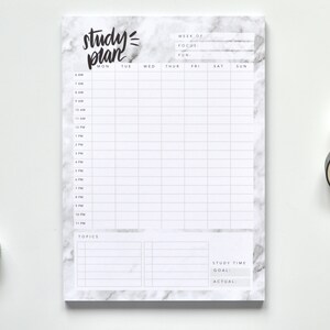 May include: A white notepad with a marble pattern and black text that says "study=plan". The notepad has a weekly schedule with columns for each day of the week and rows for each hour of the day. The notepad also has a section for topics and study time.