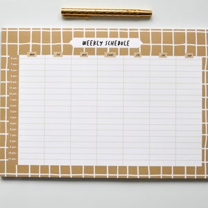 May include: A weekly schedule planner with a brown grid pattern and white lines. The planner has a tab at the top that says "Weekly Schedule" and columns for each day of the week: Mon, Tue, Wed, Thurs, Fri, Sat, Sun. The planner has rows for each hour of the day from 8 am to 11 pm.