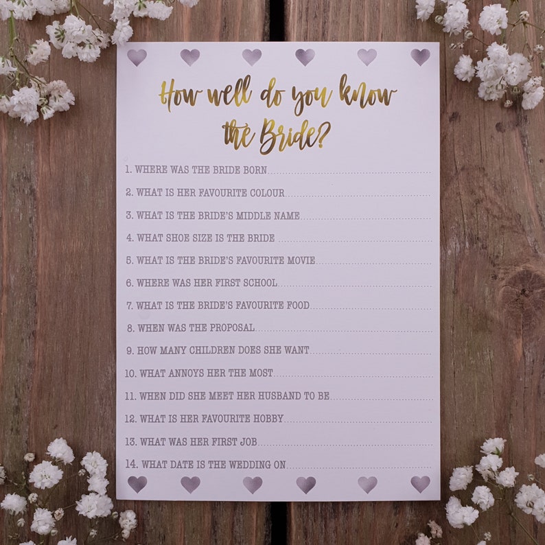 May include: A printable bridal shower game with the title "How well do you know the Bride?" and 14 questions about the bride. The game is printed on white paper with a light purple background and has a decorative border of hearts.