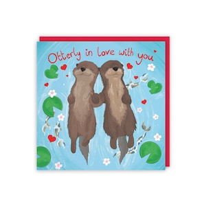 May include: A greeting card with a blue background featuring two otters holding hands. The otters are brown and have white bellies. The card has the text "Otterly in love with you" in red letters.