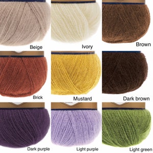 May include: Nine balls of yarn in different colours: beige, ivory, brown, brick, mustard, dark brown, dark purple, light purple, and light green.