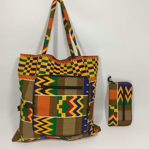 May include: A patterned tote bag and purse set. The bag has a large front pocket with a zip and a vibrant geometric design in yellow, orange, green, and blue. The purse has a similar design. The bag has long straps for carrying.
