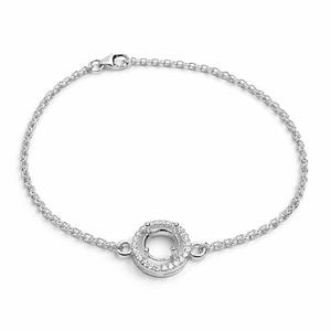 Puede incluir: Una pulsera de plata con una cadena fina y un colgante circular. El colgante está adornado con pequeñas piedras brillantes en el borde exterior, rodeando un engaste central. La pulsera tiene un cierre de mosquetón.