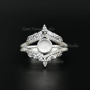 May include: Silver ring with a round bezel setting and a row of clear cubic zirconia stones on each side. The ring is designed to hold a cabochon stone.