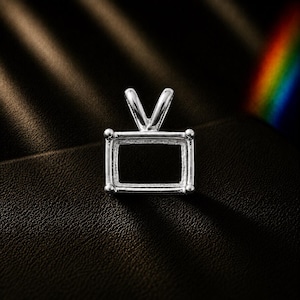 May include: A silver-toned metal pendant setting featuring a rectangular frame with four prongs at the corners and a V-shaped bail at the top. The setting is empty, designed to hold a rectangular gemstone, and has a polished, reflective metallic finish.