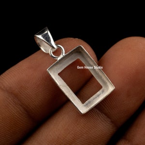 Peut inclure: Pendentif en argent avec un cadre rectangulaire pour une pierre précieuse. Le pendentif a une bélière pour l'attacher à une chaîne. Gem House Studio est imprimé sur le cadre.