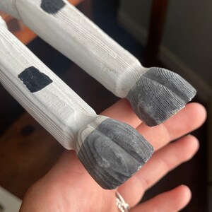 Close up of hand carved wooden cow's jointed legs, image focuses on its hooves