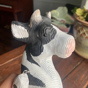 Close up image of hand carved wooden cow figurine face