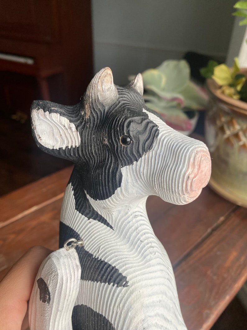 Close up image of hand carved wooden cow figurine face