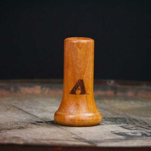 May include: A wooden baseball bat-shaped bottle stopper with a brown wood finish and a laser-engraved Arizona Diamondbacks logo.