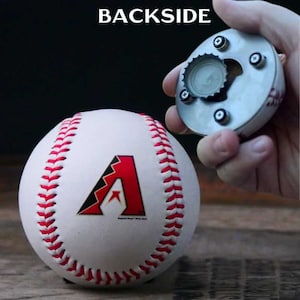 May include: A white baseball with red stitching and a red and black logo. A metal bottle opener with a baseball design is held nearby. The word "BACKSIDE" is printed at the top of the image.